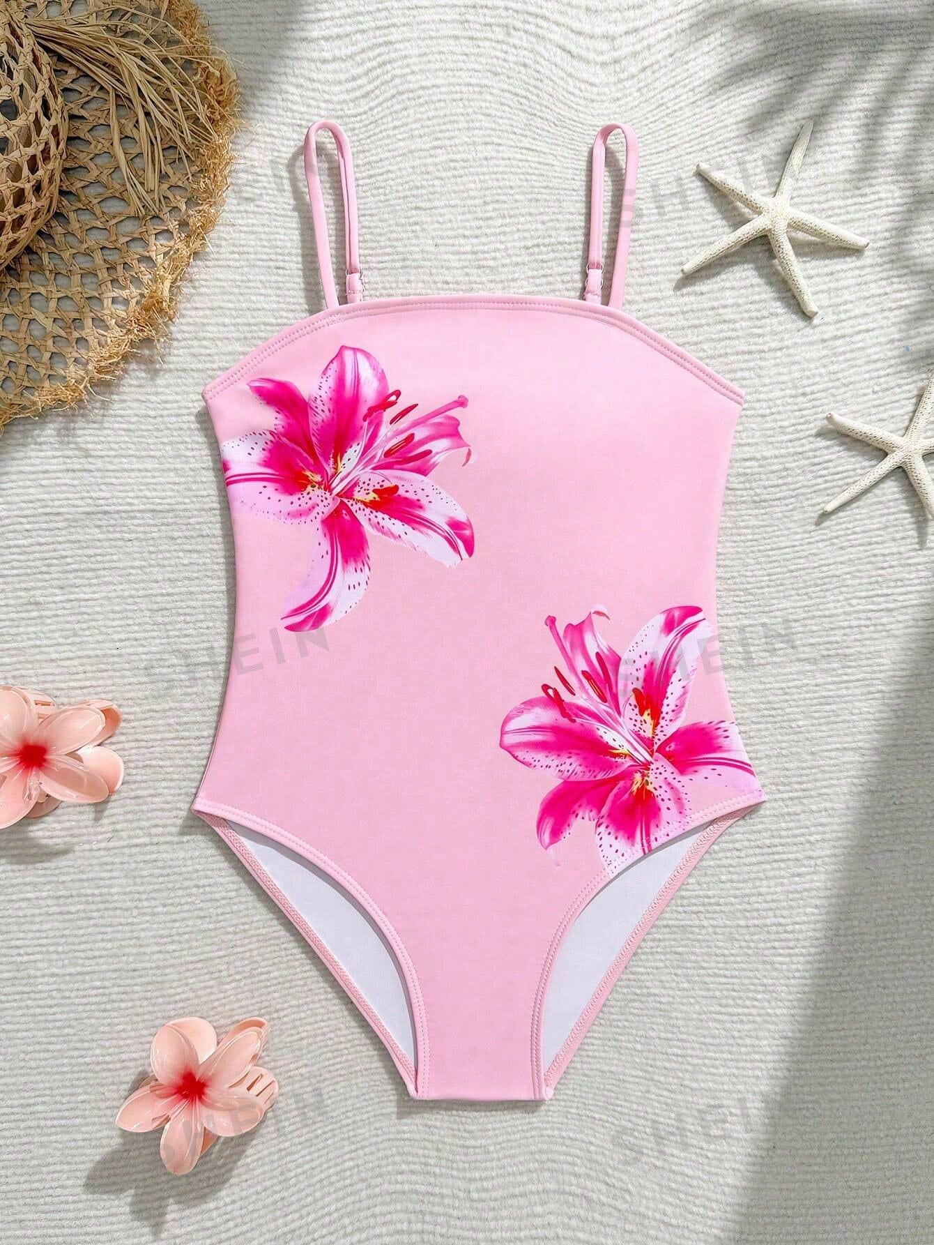 Tween girls one-piece swimsuit with a floral plant print, spaghetti straps, and a mid-waist fit in black.
