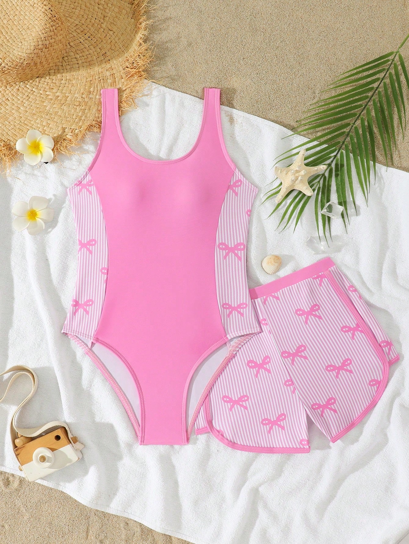 Tween girls 2-piece swimsuit set in black with full floral and plant print, featuring a sleeveless scoop-neck swim top and matching shorts-style bottoms.