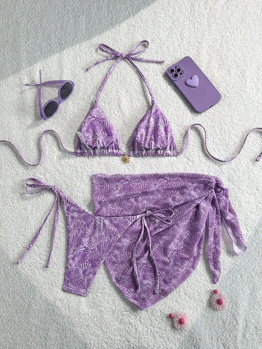 Women's 3-piece blue tropical shell print bikini set featuring a halter bralette top, low-waist tie-side bottom, and a matching sheer mesh cover-up skirt.