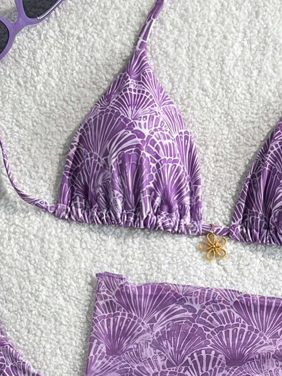 Women's 3-piece blue tropical shell print bikini set featuring a halter bralette top, low-waist tie-side bottom, and a matching sheer mesh cover-up skirt.