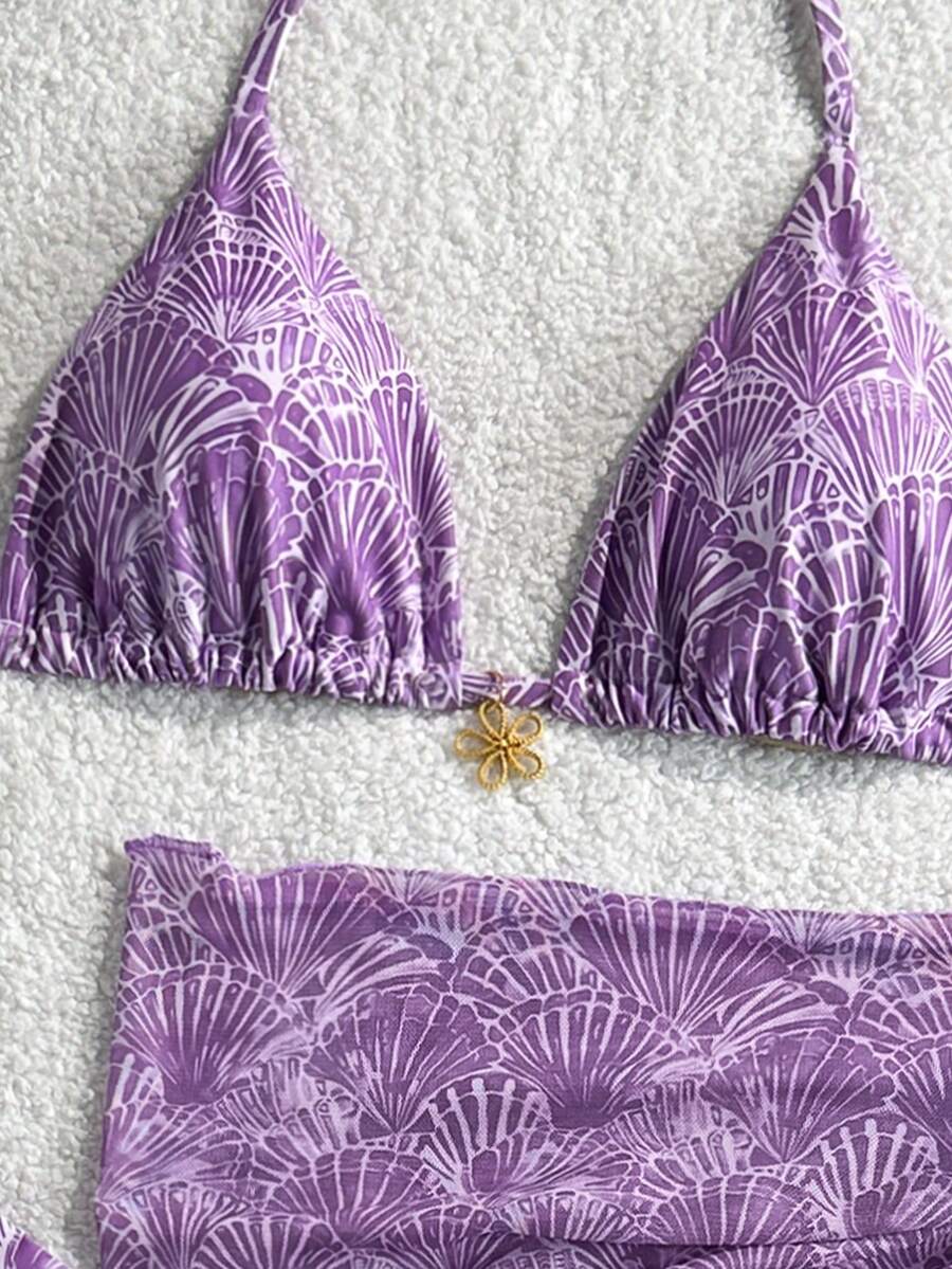Women's 3-piece blue tropical shell print bikini set featuring a halter bralette top, low-waist tie-side bottom, and a matching sheer mesh cover-up skirt.