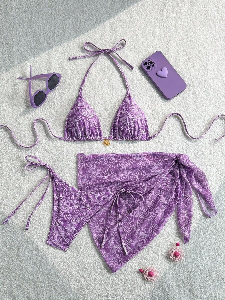 Women's 3-piece blue tropical shell print bikini set featuring a halter bralette top, low-waist tie-side bottom, and a matching sheer mesh cover-up skirt.
