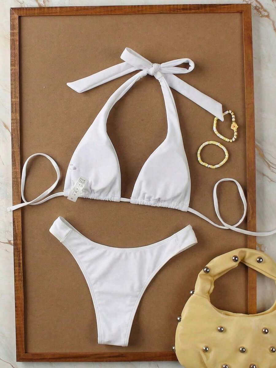 Women's halter neck bikini swimwear set featuring a wireless bra top with removable padding and mid waist bikini bottom.