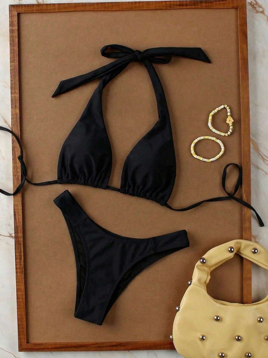 Women's halter neck bikini swimwear set featuring a wireless bra top with removable padding and mid waist bikini bottom.