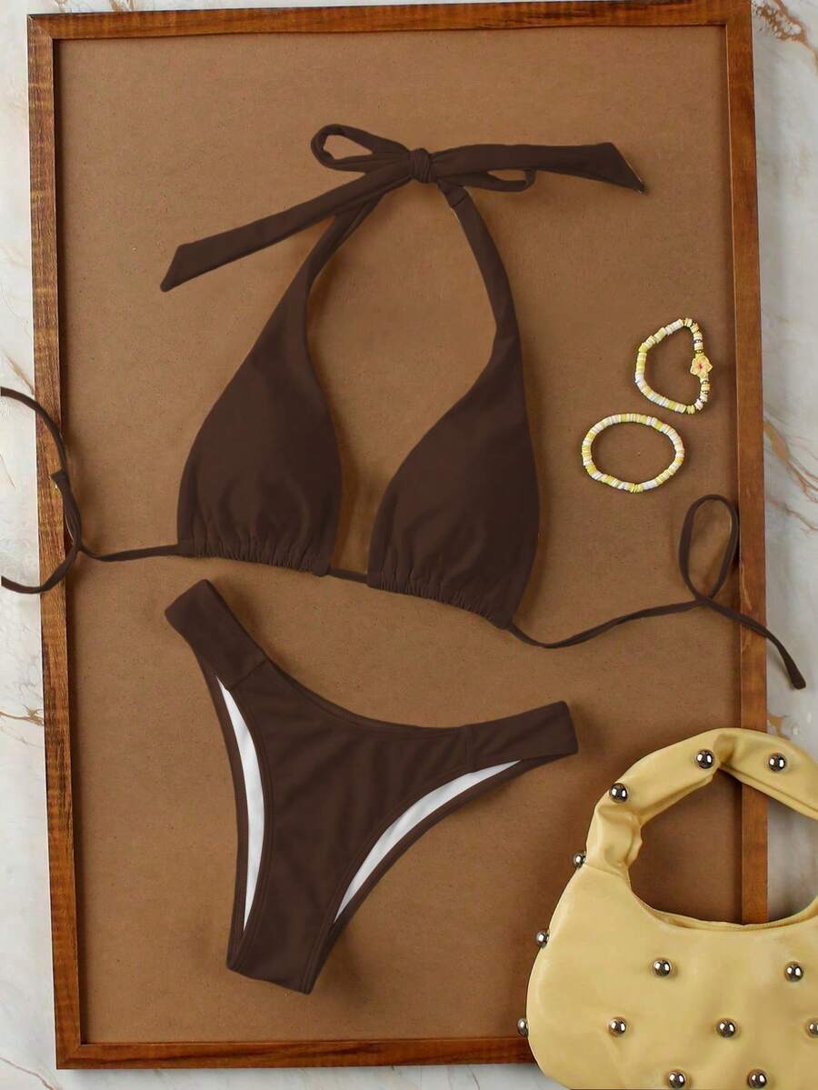 Women's halter neck bikini swimwear set featuring a wireless bra top with removable padding and mid waist bikini bottom.