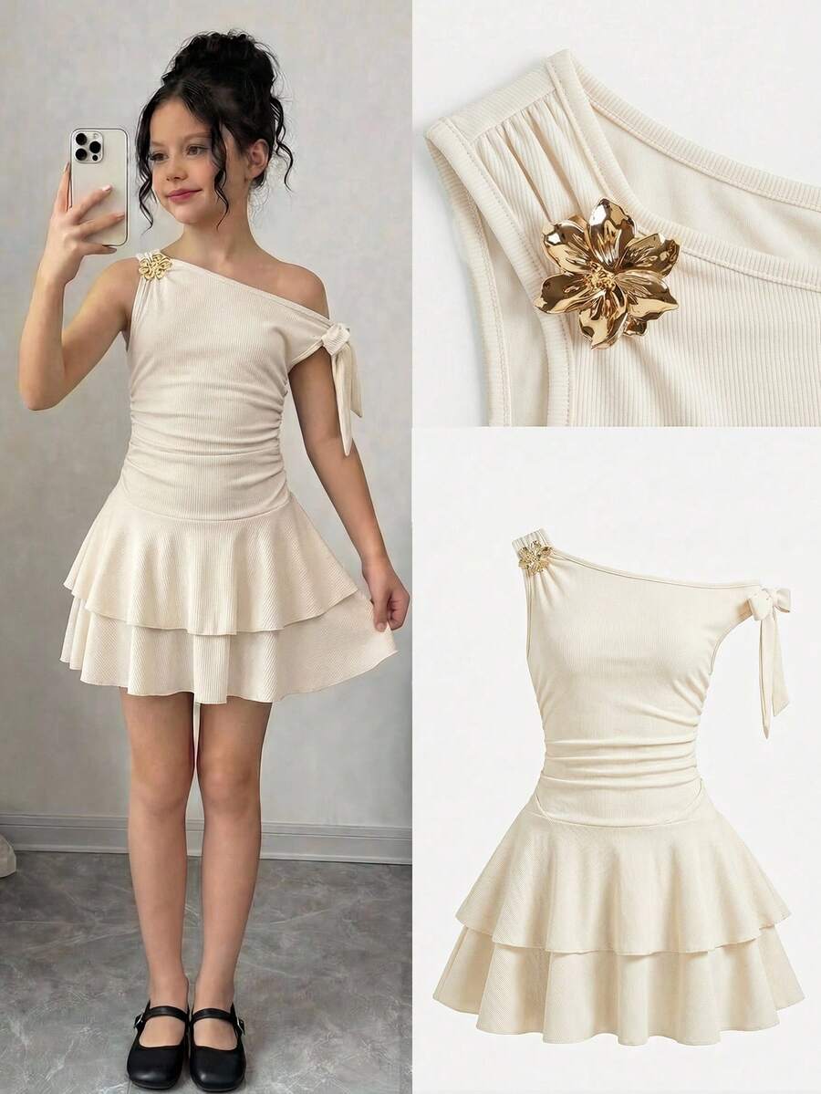 Tween girl wearing an apricot asymmetrical tiered sleeveless party dress with an A-line silhouette.