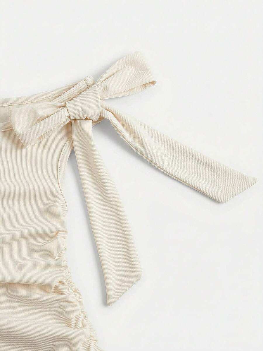 Tween girl wearing an apricot asymmetrical tiered sleeveless party dress with an A-line silhouette.