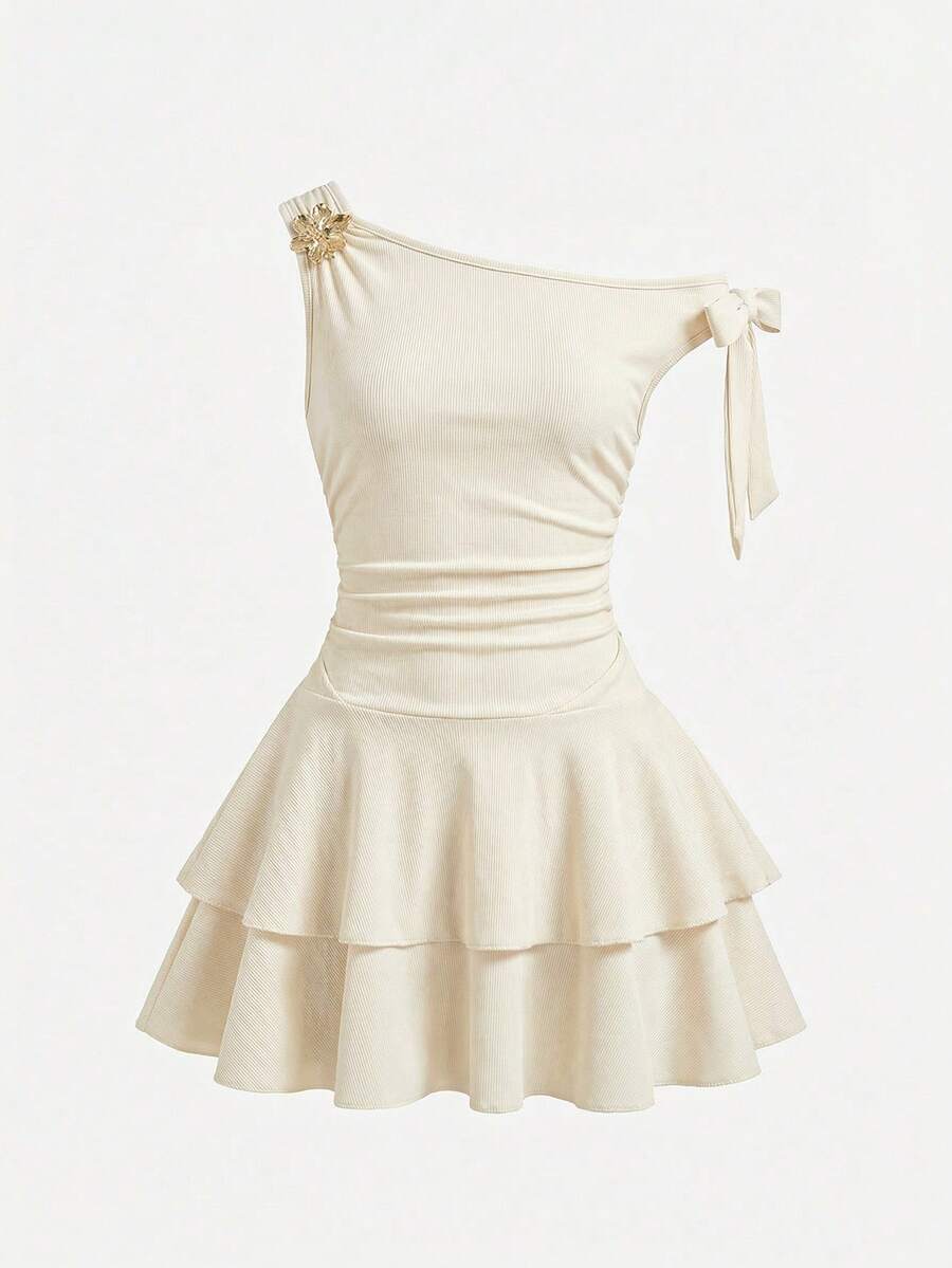 Tween girl wearing an apricot asymmetrical tiered sleeveless party dress with an A-line silhouette.
