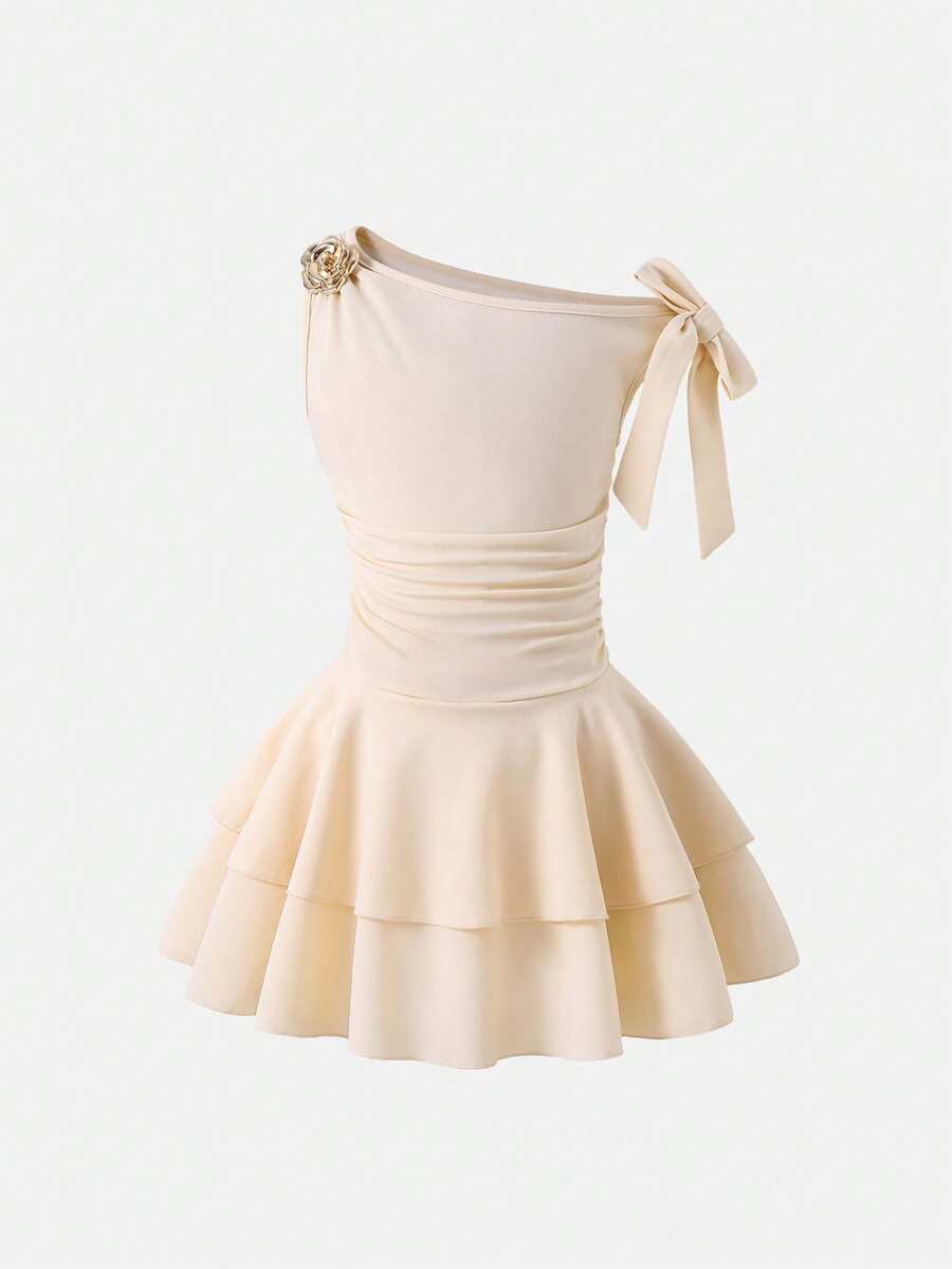 Tween girl wearing an apricot asymmetric skater dress with ruffle and applique details for party and formal occasions.