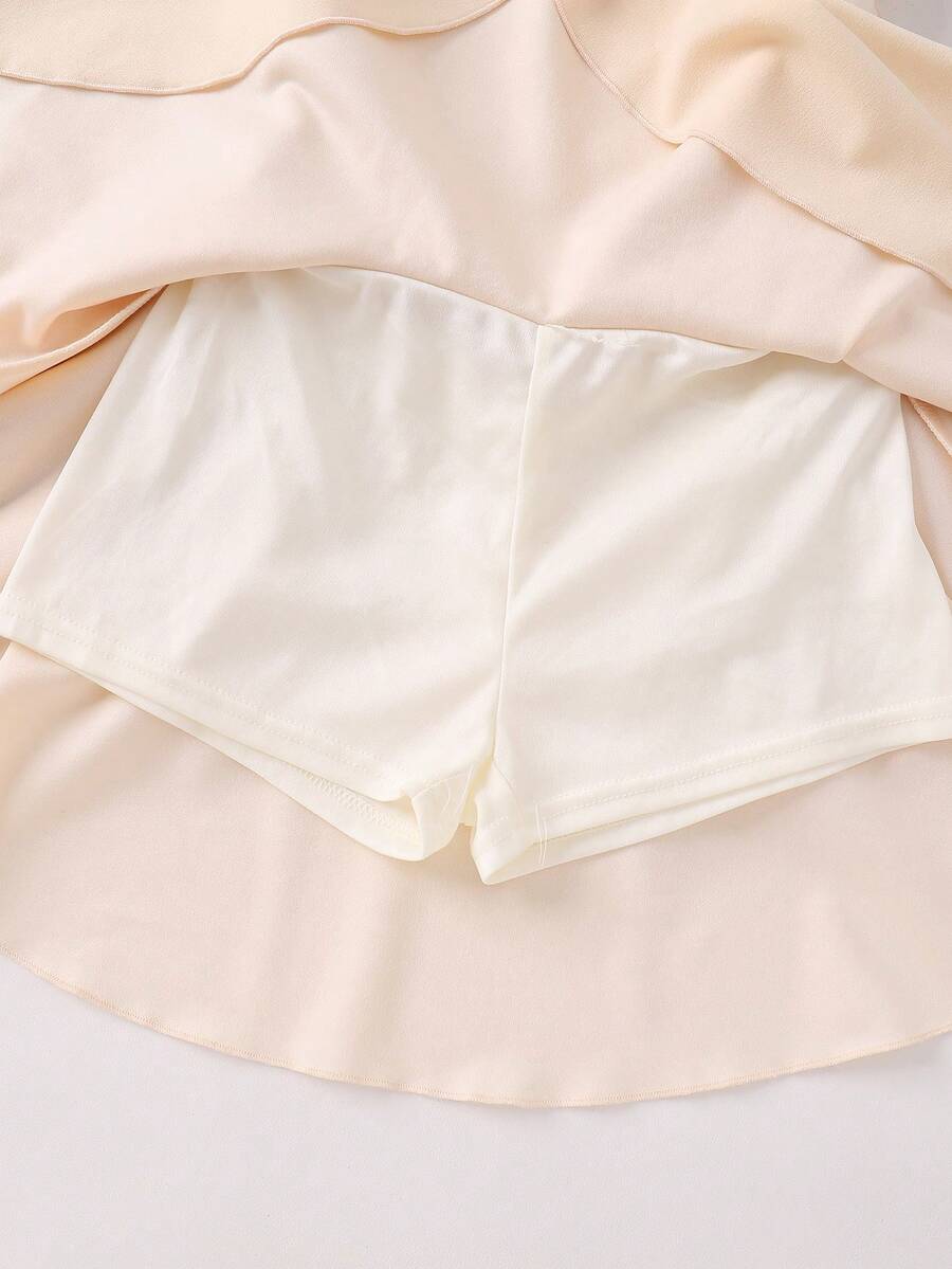Tween girl wearing an apricot asymmetric skater dress with ruffle and applique details for party and formal occasions.