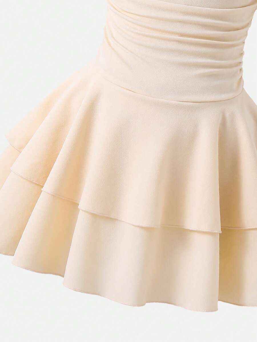 Tween girl wearing an apricot asymmetric skater dress with ruffle and applique details for party and formal occasions.
