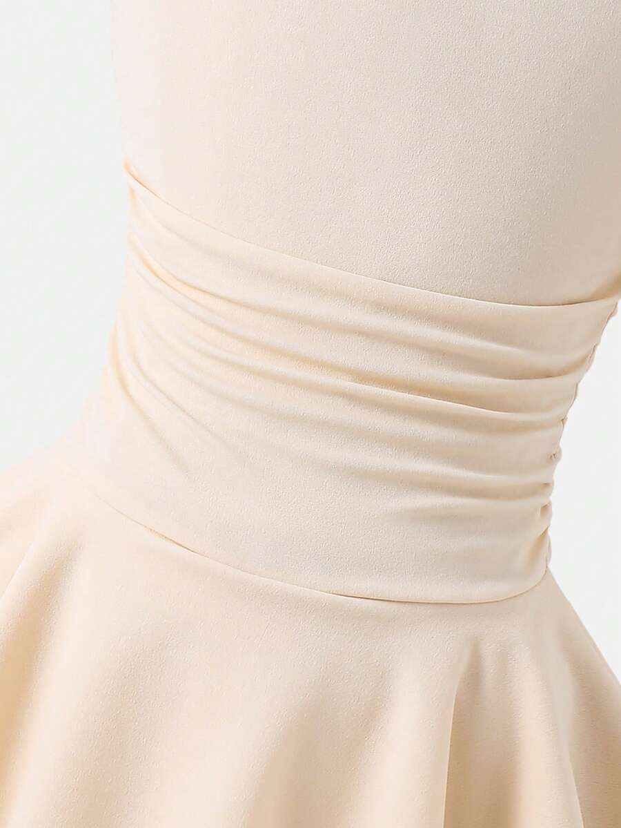Tween girl wearing an apricot asymmetric skater dress with ruffle and applique details for party and formal occasions.