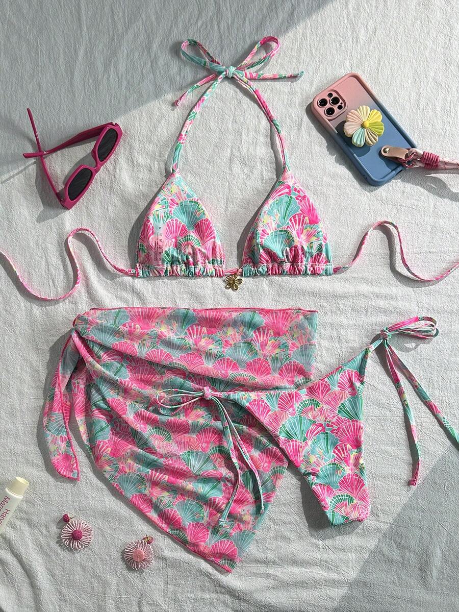 Women's 3-piece blue tropical shell print bikini set featuring a halter bralette top, low-waist tie-side bottom, and a matching sheer mesh cover-up skirt.