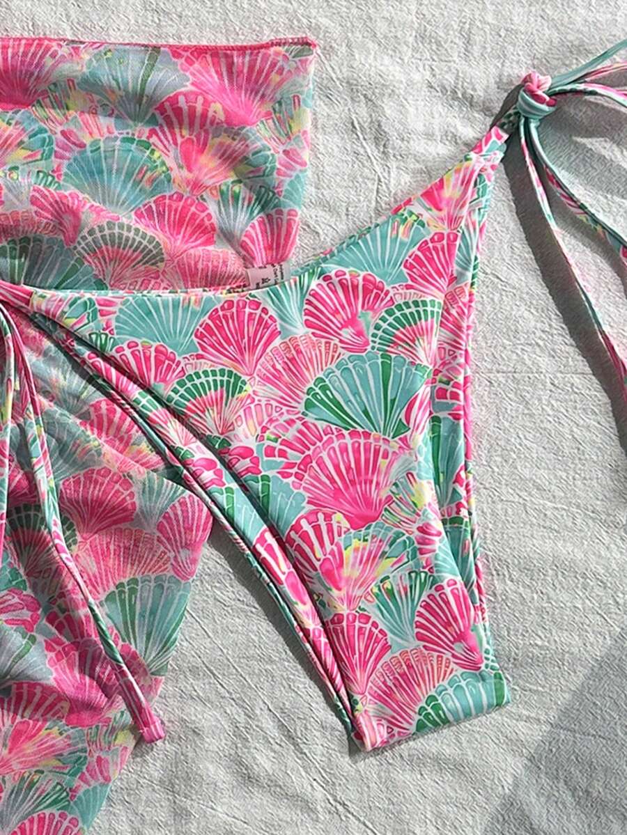 Women's 3-piece blue tropical shell print bikini set featuring a halter bralette top, low-waist tie-side bottom, and a matching sheer mesh cover-up skirt.