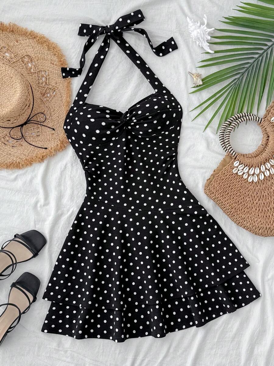 Black sleeveless halter polka dot mini dress for tween girls featuring a high waist and flared hem
