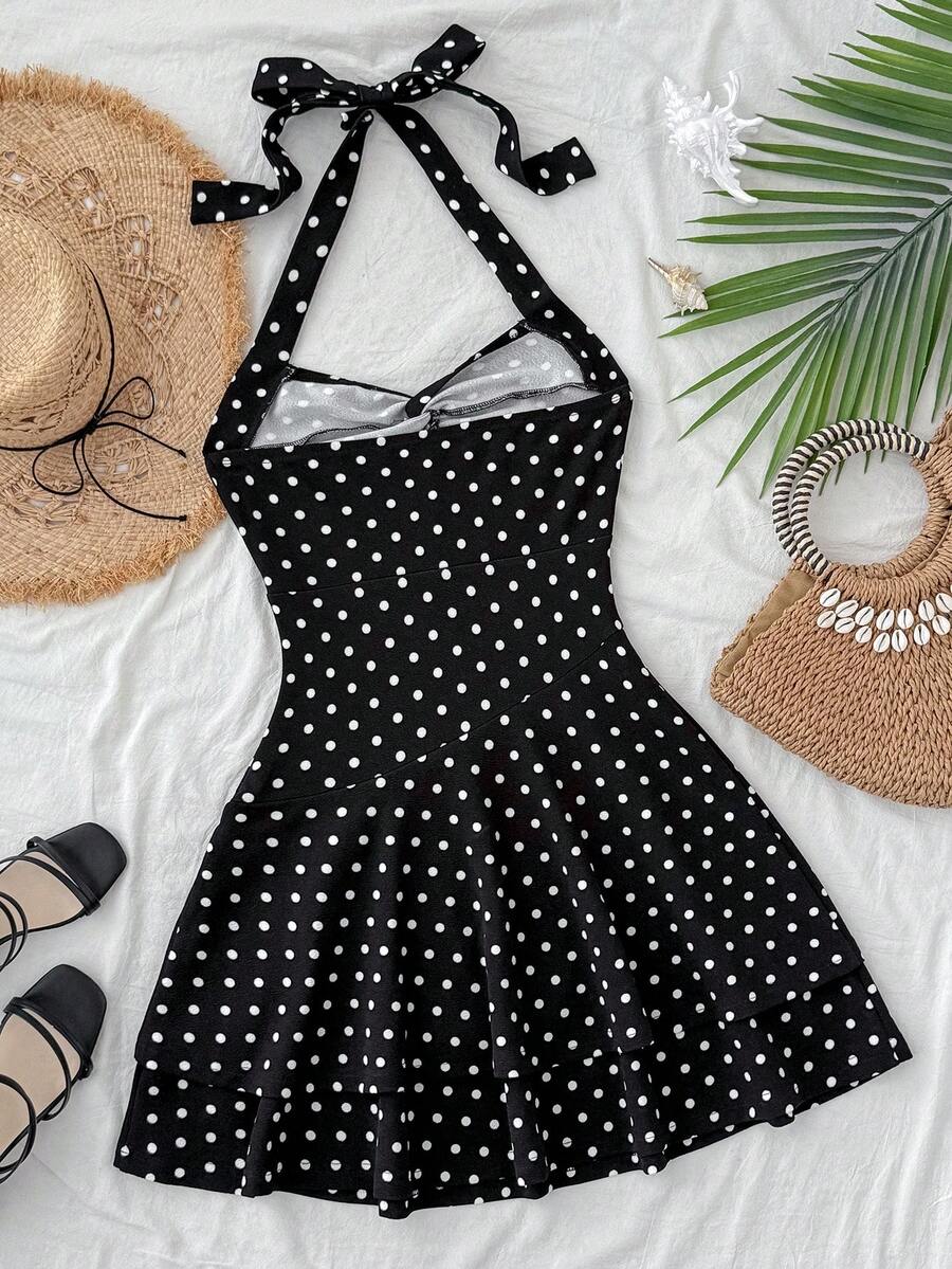Black sleeveless halter polka dot mini dress for tween girls featuring a high waist and flared hem