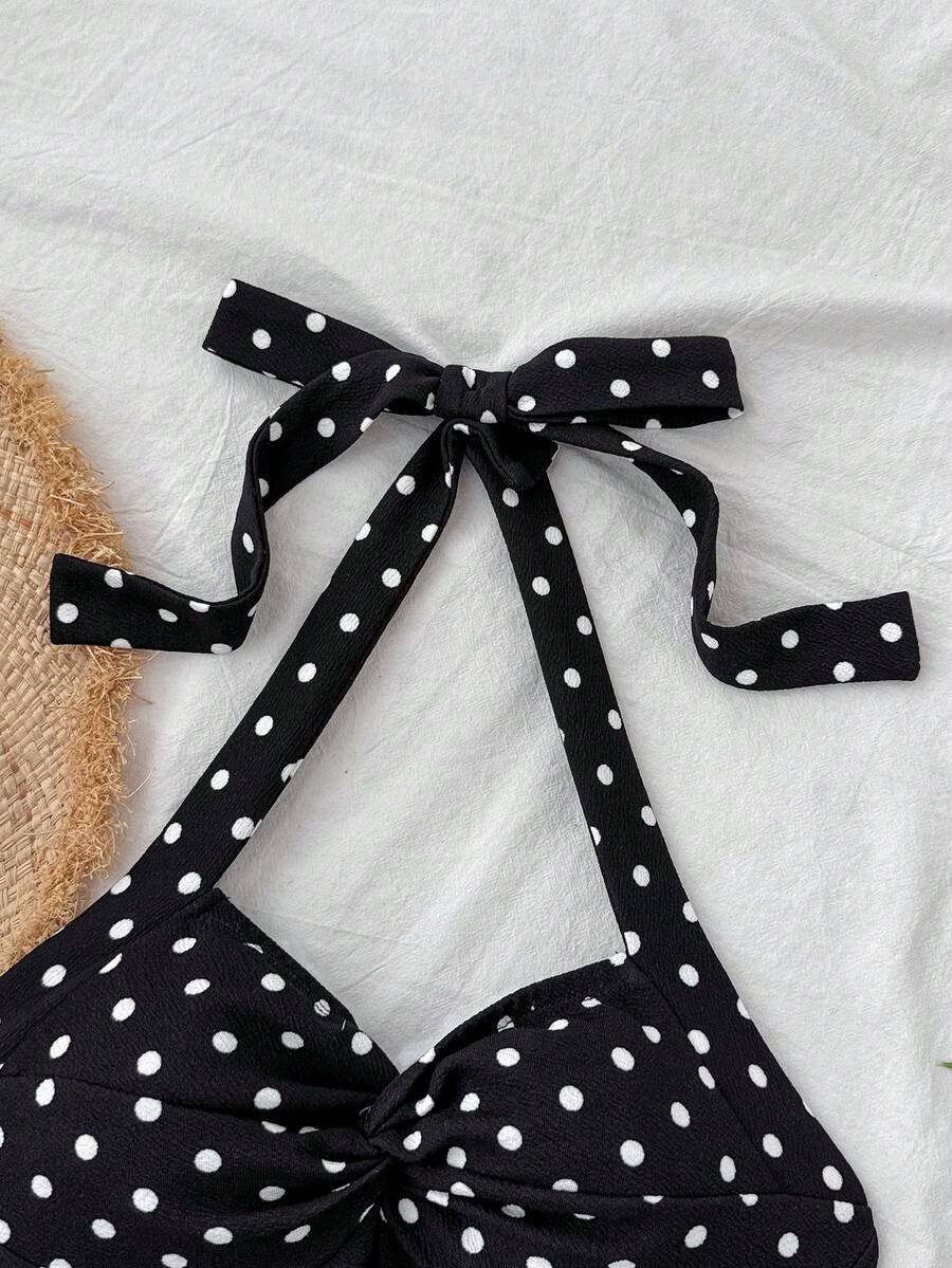 Black sleeveless halter polka dot mini dress for tween girls featuring a high waist and flared hem