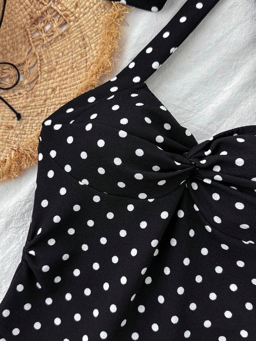 Black sleeveless halter polka dot mini dress for tween girls featuring a high waist and flared hem