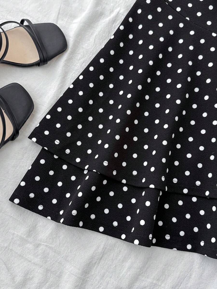 Black sleeveless halter polka dot mini dress for tween girls featuring a high waist and flared hem