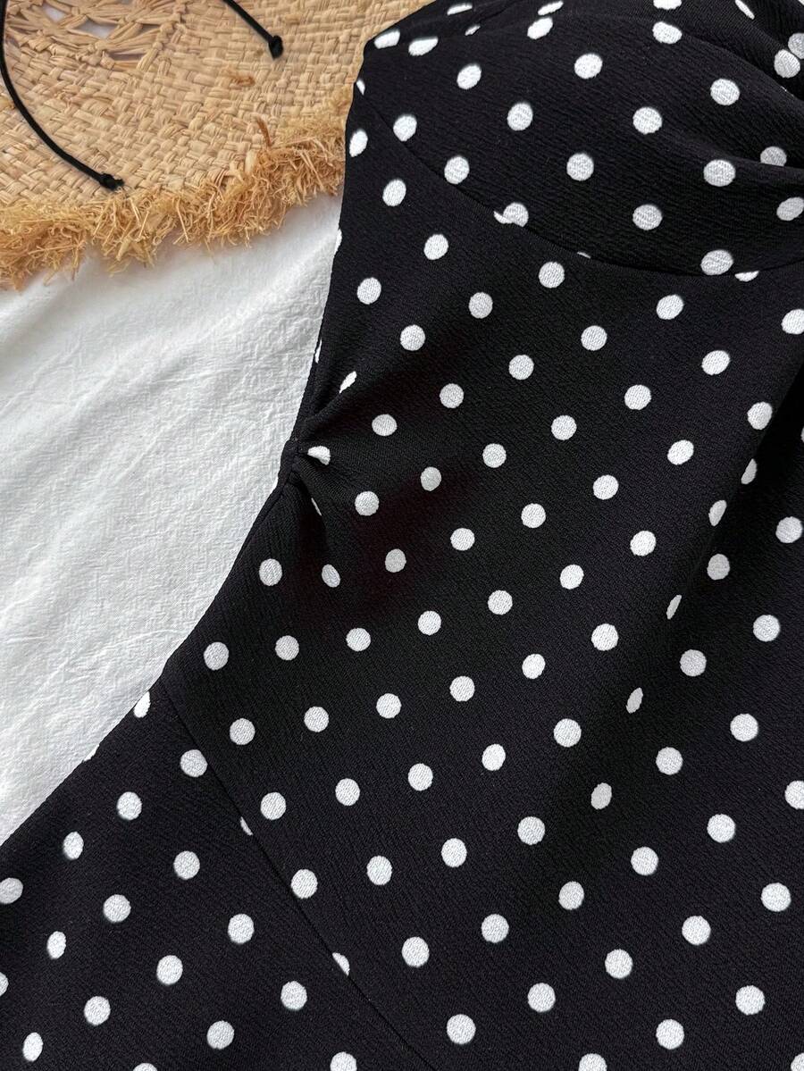 Black sleeveless halter polka dot mini dress for tween girls featuring a high waist and flared hem