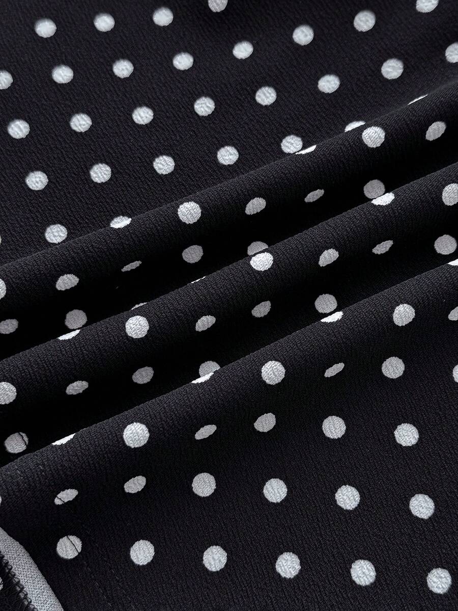 Black sleeveless halter polka dot mini dress for tween girls featuring a high waist and flared hem
