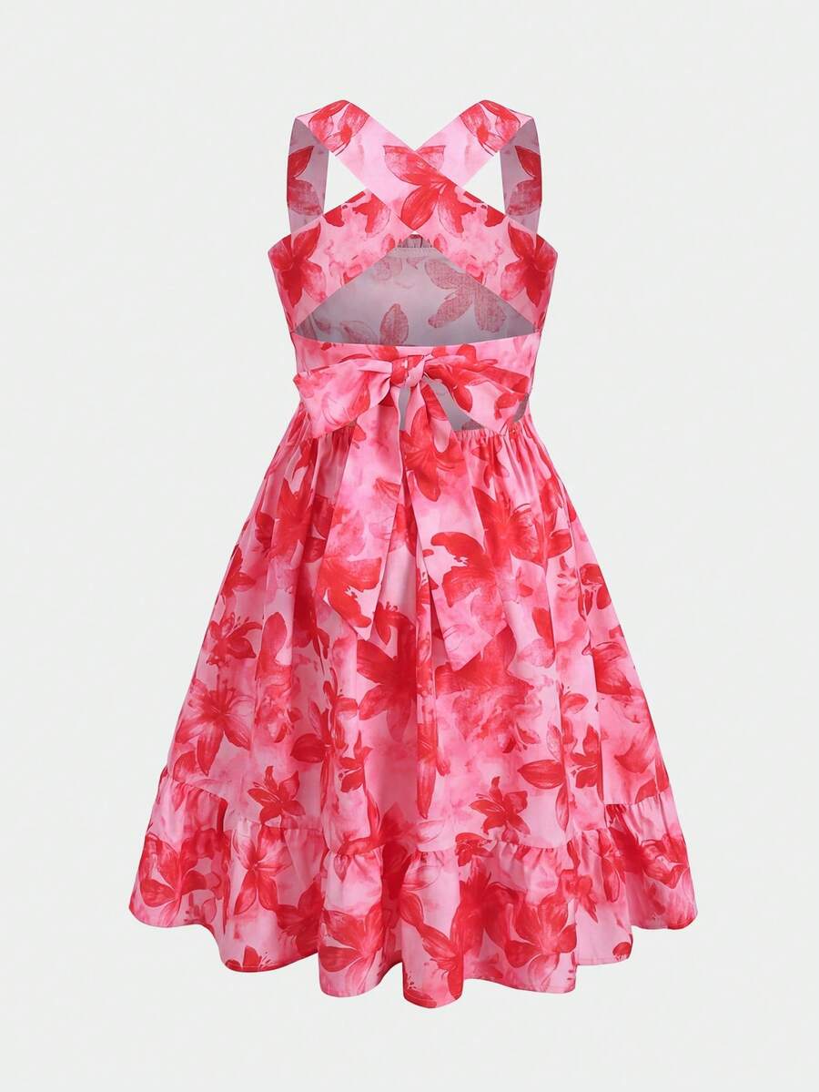 Pink sleeveless tween girls vacation dress with all-over fruit and vegetable print, strap neckline, belted high waist, cut-out detail, and flared ruffle hem.