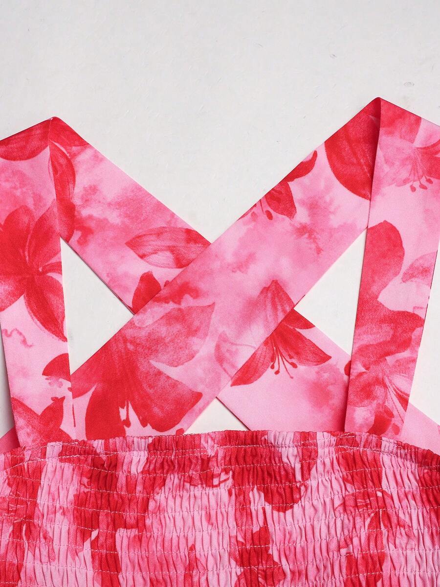 Pink sleeveless tween girls vacation dress with all-over fruit and vegetable print, strap neckline, belted high waist, cut-out detail, and flared ruffle hem.