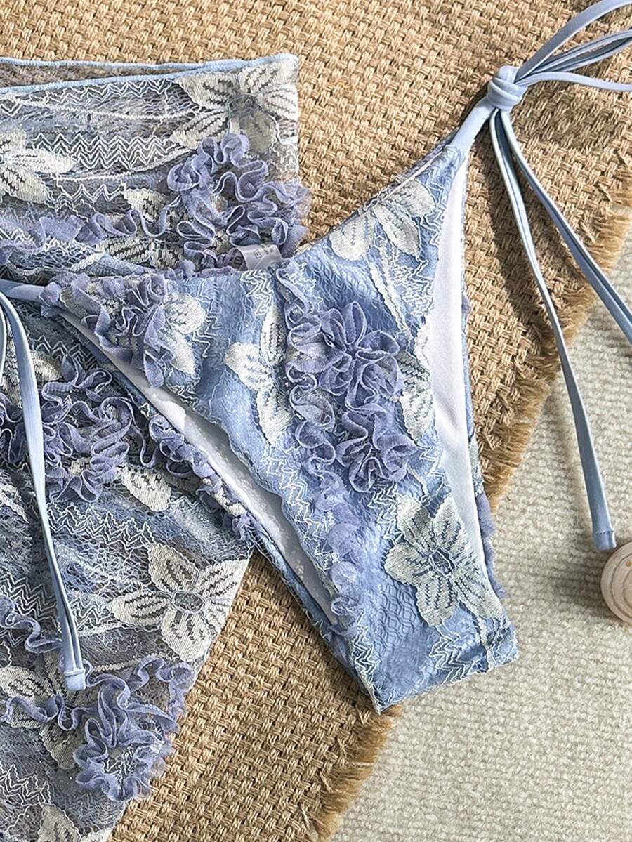 Women's 3-piece blue tropical shell print bikini set featuring a halter bralette top, low-waist tie-side bottom, and a matching sheer mesh cover-up skirt.