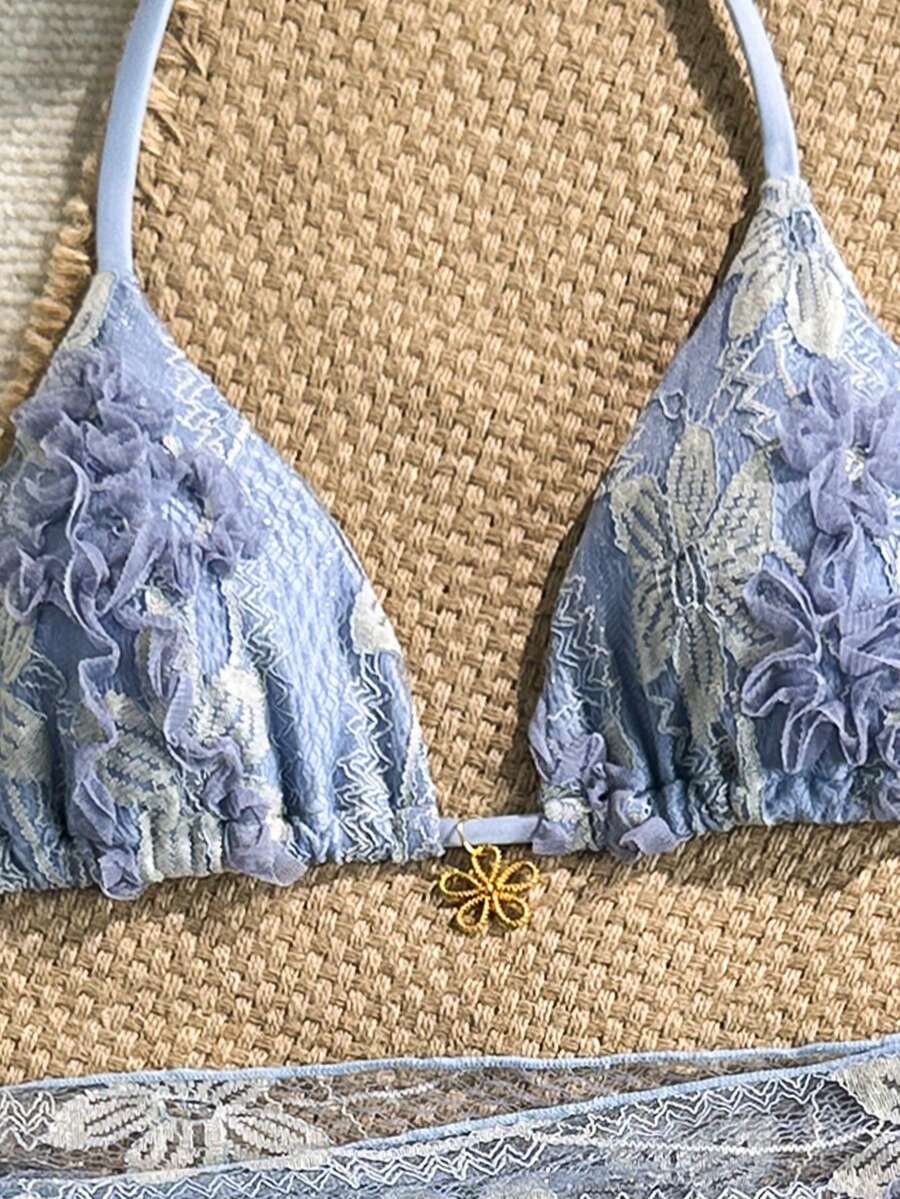Women's 3-piece blue tropical shell print bikini set featuring a halter bralette top, low-waist tie-side bottom, and a matching sheer mesh cover-up skirt.