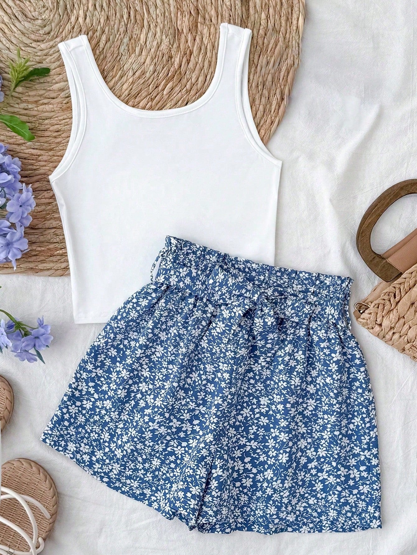 Tween girl summer two-piece outfit featuring a white scoop neck tank top and green ditsy floral print paperbag waist shorts with belt.