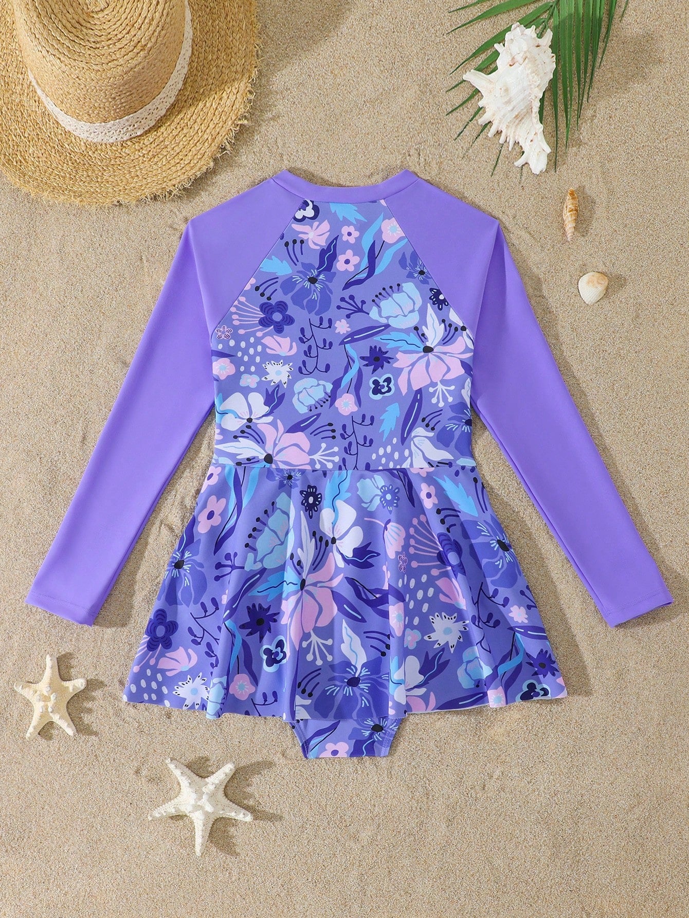 Purple tween girls one-piece swimsuit with graphic striped print, ruffle detail, round neck, and zipper closure for swimming and vacation wear