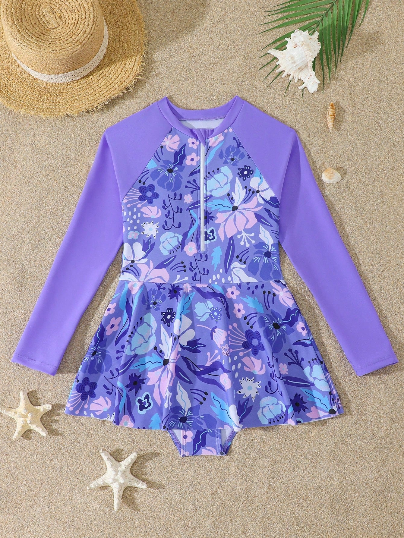 Purple tween girls one-piece swimsuit with graphic striped print, ruffle detail, round neck, and zipper closure for swimming and vacation wear