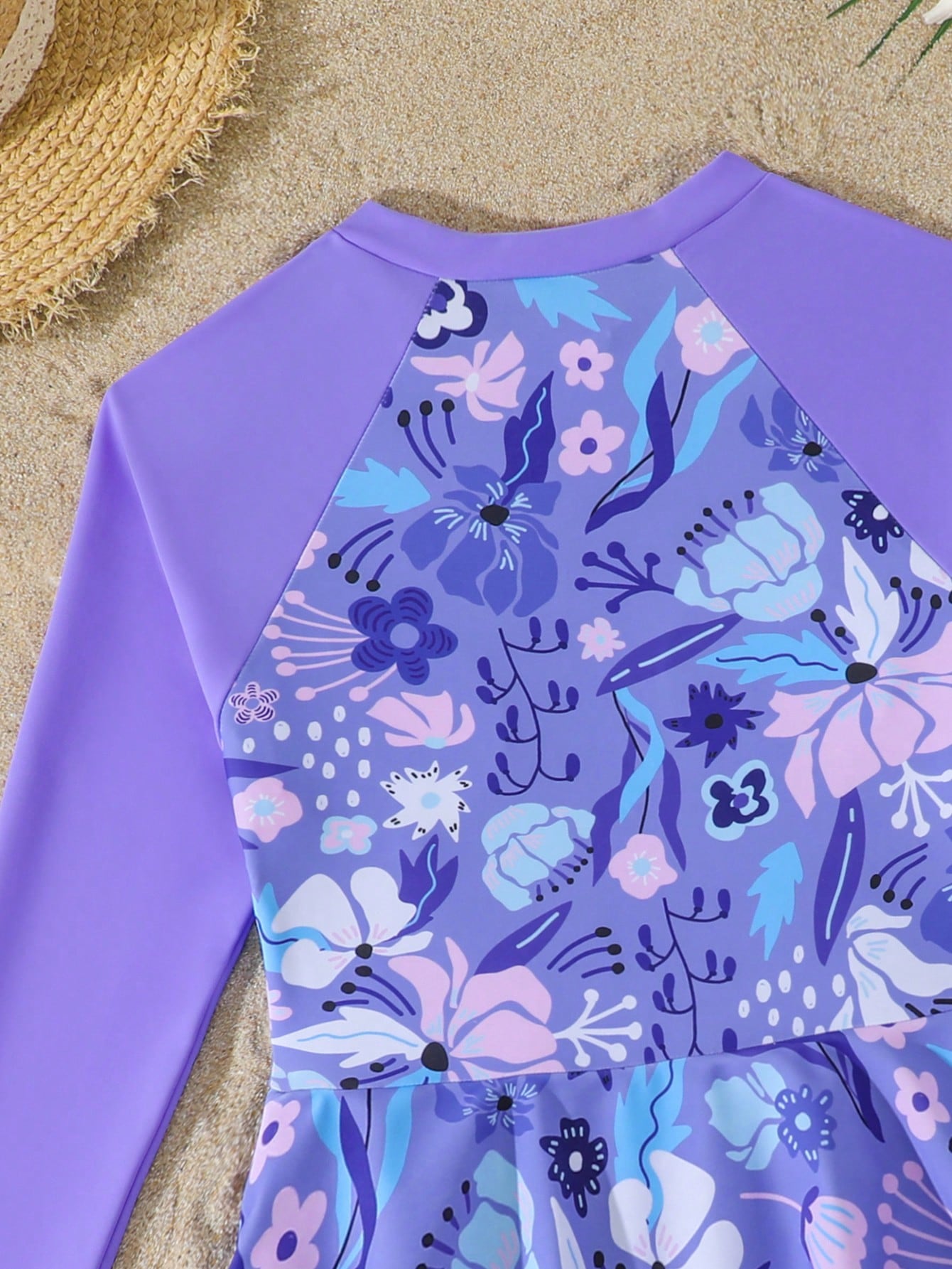 Purple tween girls one-piece swimsuit with graphic striped print, ruffle detail, round neck, and zipper closure for swimming and vacation wear