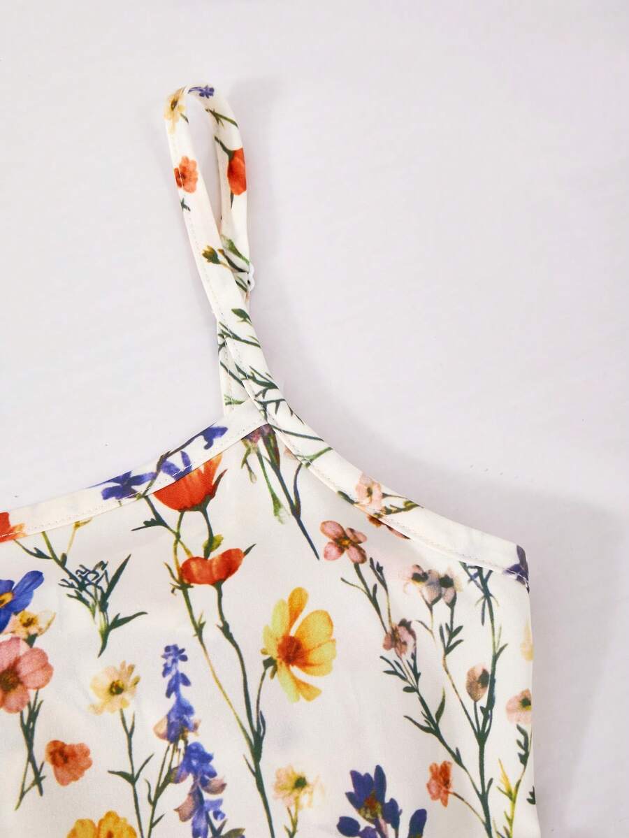 Tween girl wearing an apricot floral print sleeveless mini cami dress featuring spaghetti straps, a shirred high waist, flounce hem, and a bow back detail.