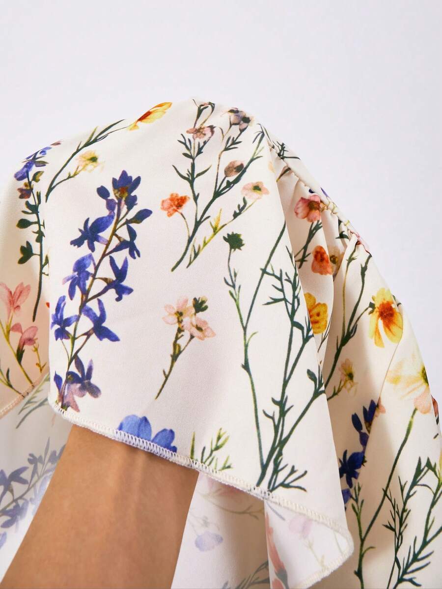 Tween girl wearing an apricot floral print sleeveless mini cami dress featuring spaghetti straps, a shirred high waist, flounce hem, and a bow back detail.