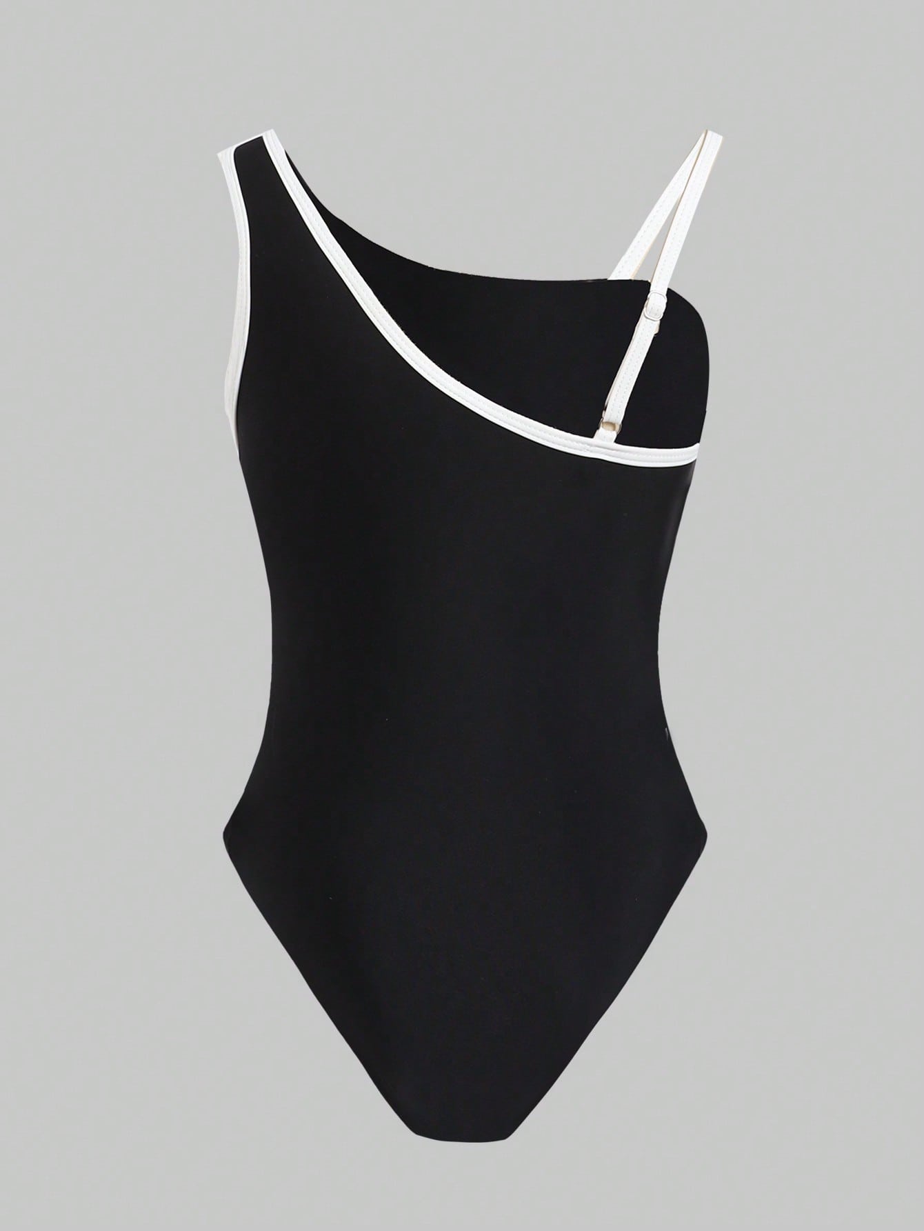 Tween girl one-piece swimsuit in brown polka dot geometric print with asymmetrical neckline, ruffle detail, cut-out design, and fitted mid-waist swim bottom.