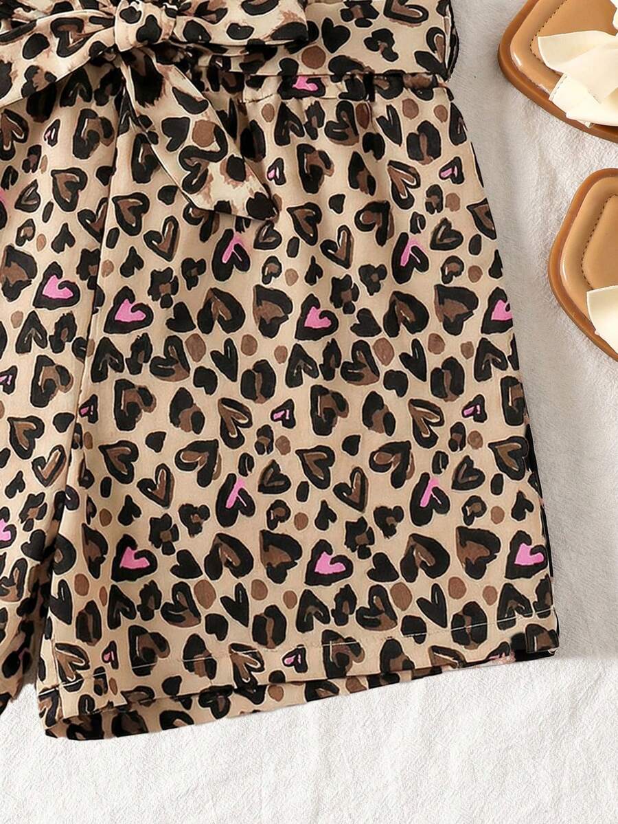 Tween girl wearing a casual 2-piece set featuring a black rib-knit scoop neck tank top and leopard print paperbag waist shorts with a matching belt.