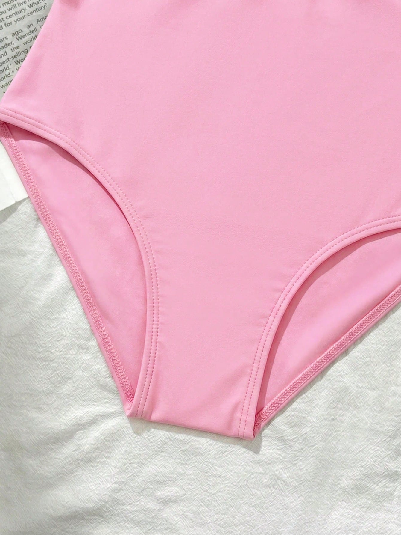 Tween girls' one-piece swimsuit featuring a ruffle splice front, ruched detailing, bow accent, contrast lace trim, and spaghetti straps.