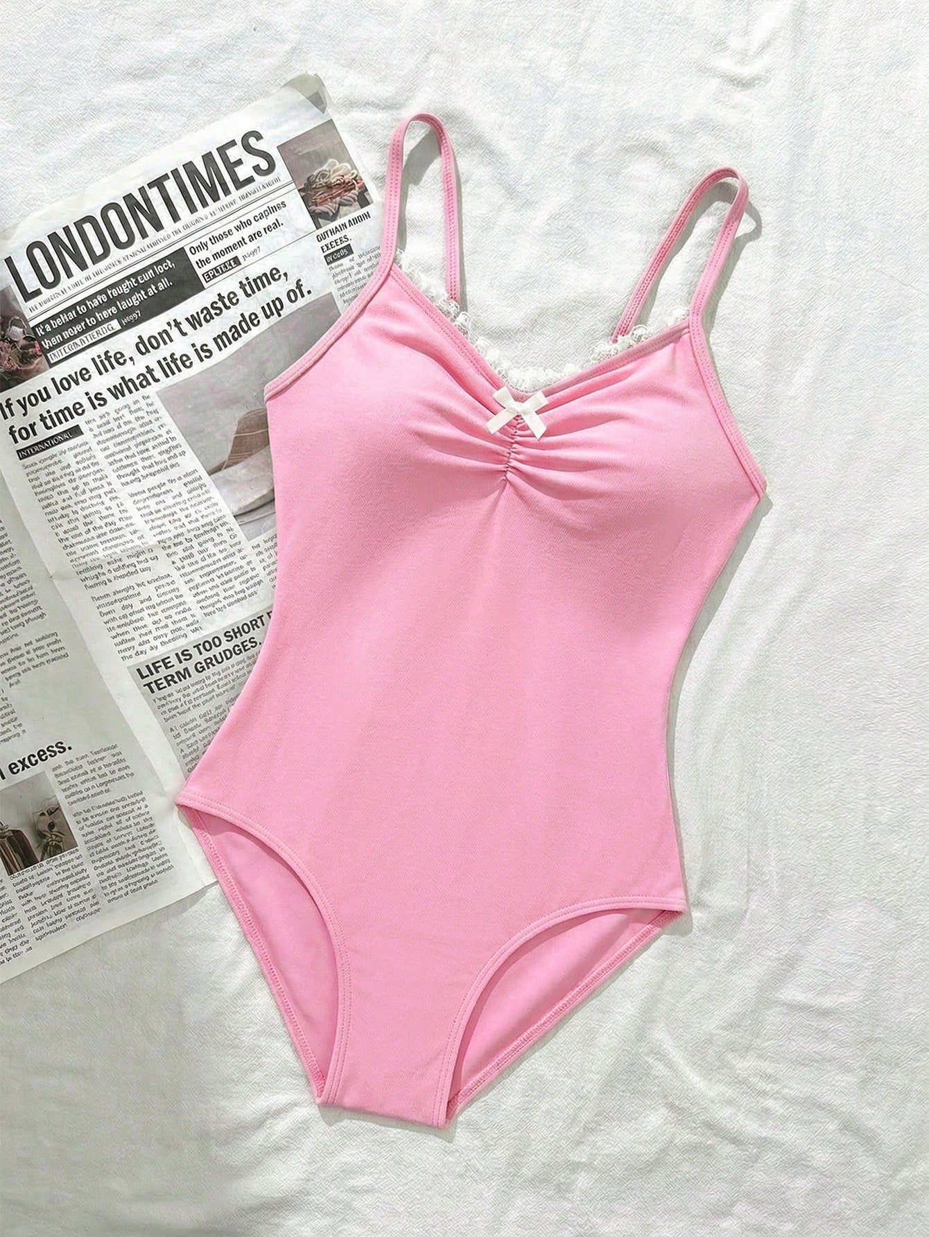 Tween girls' one-piece swimsuit featuring a ruffle splice front, ruched detailing, bow accent, contrast lace trim, and spaghetti straps.