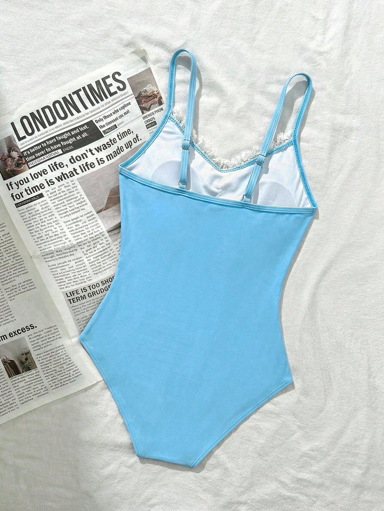 Tween girls' one-piece swimsuit featuring a ruffle splice front, ruched detailing, bow accent, contrast lace trim, and spaghetti straps.