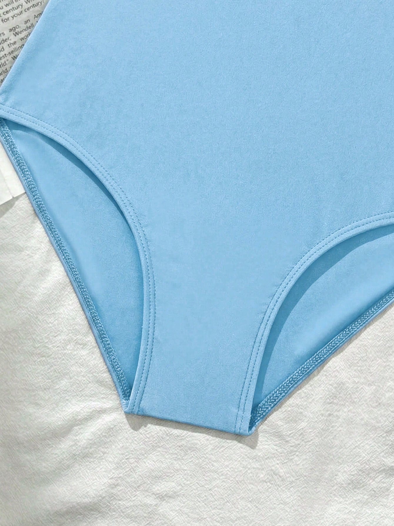 Tween girls' one-piece swimsuit featuring a ruffle splice front, ruched detailing, bow accent, contrast lace trim, and spaghetti straps.