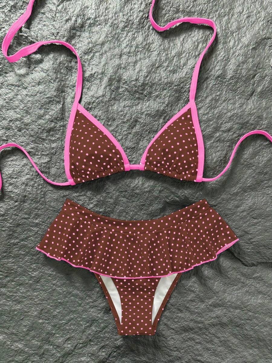 Women's 70s retro black and white polka dot bikini set featuring a halter triangle top and ultra low waist bottoms.