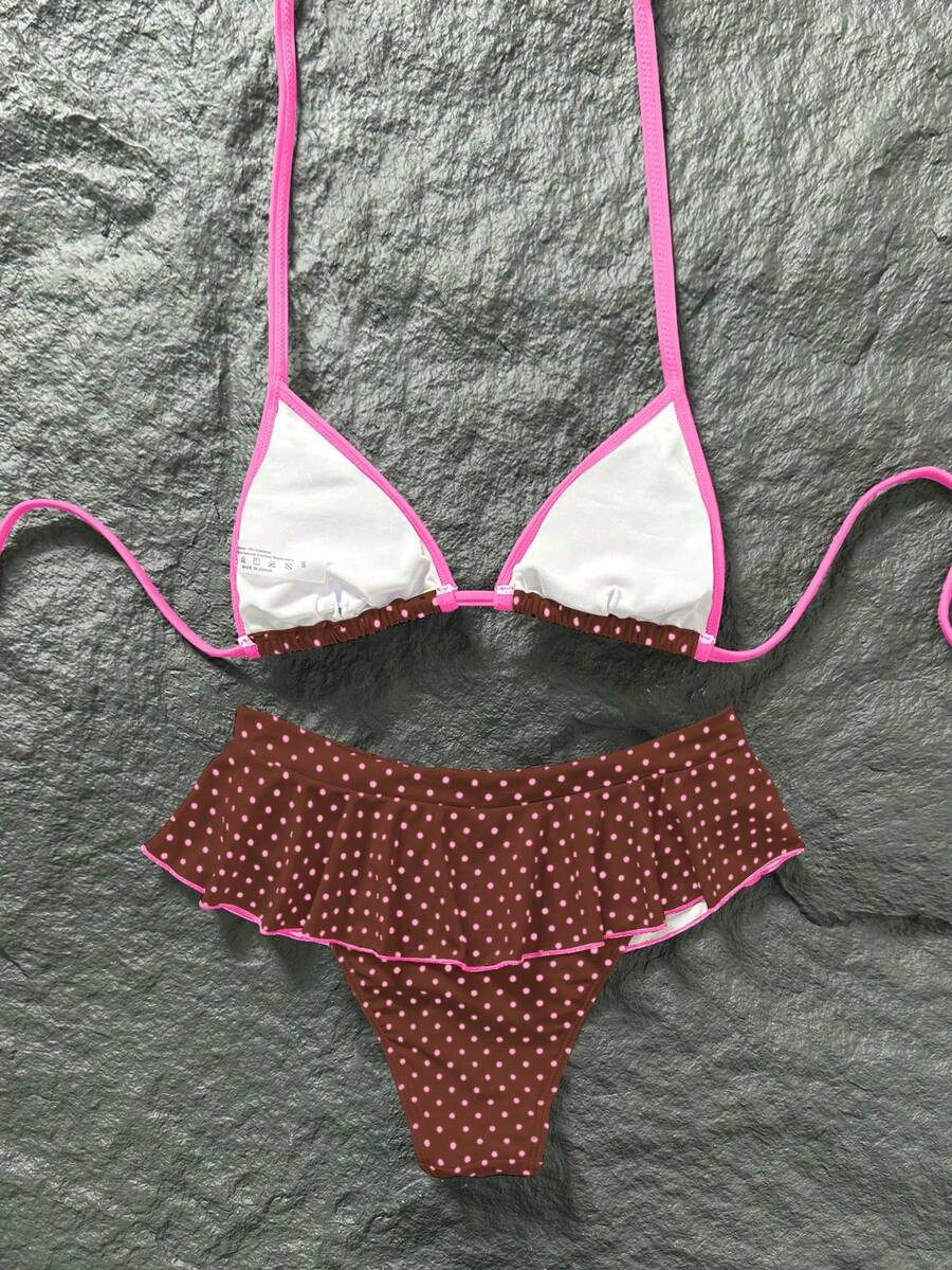 Women's 70s retro black and white polka dot bikini set featuring a halter triangle top and ultra low waist bottoms.