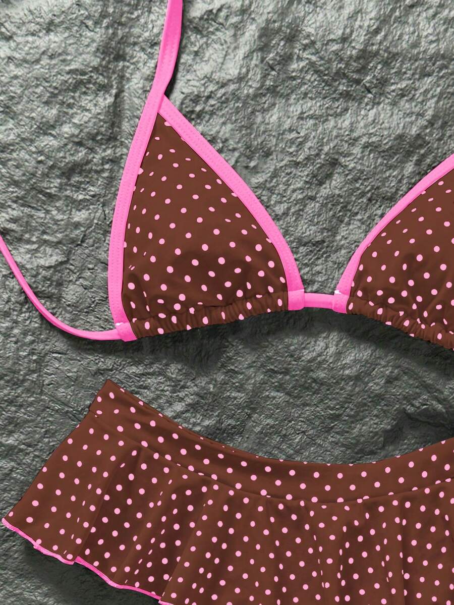 Women's 70s retro black and white polka dot bikini set featuring a halter triangle top and ultra low waist bottoms.