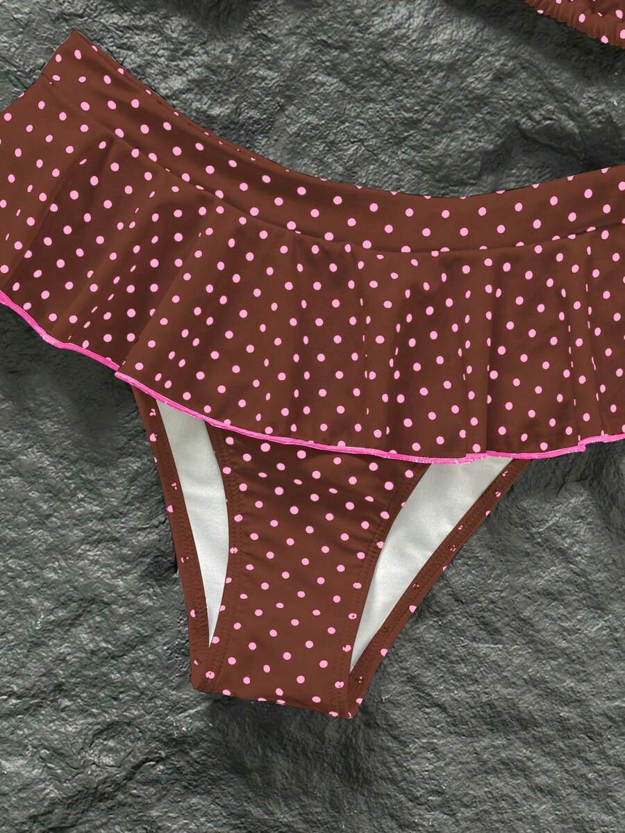 Women's 70s retro black and white polka dot bikini set featuring a halter triangle top and ultra low waist bottoms.