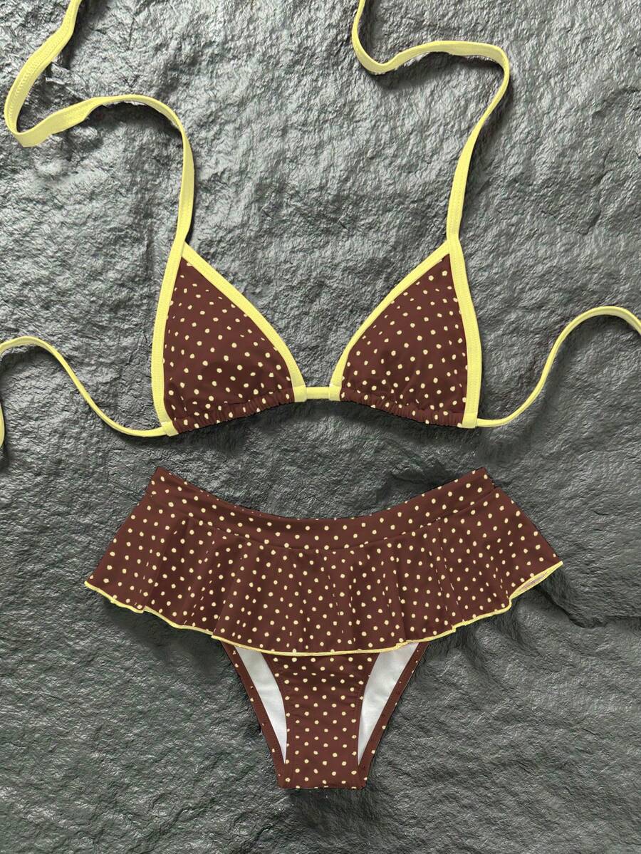 Women's 70s retro black and white polka dot bikini set featuring a halter triangle top and ultra low waist bottoms.