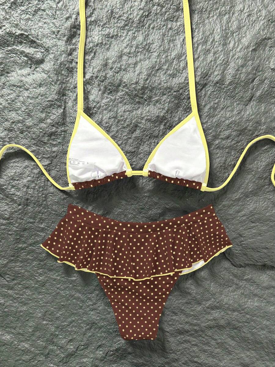 Women's 70s retro black and white polka dot bikini set featuring a halter triangle top and ultra low waist bottoms.