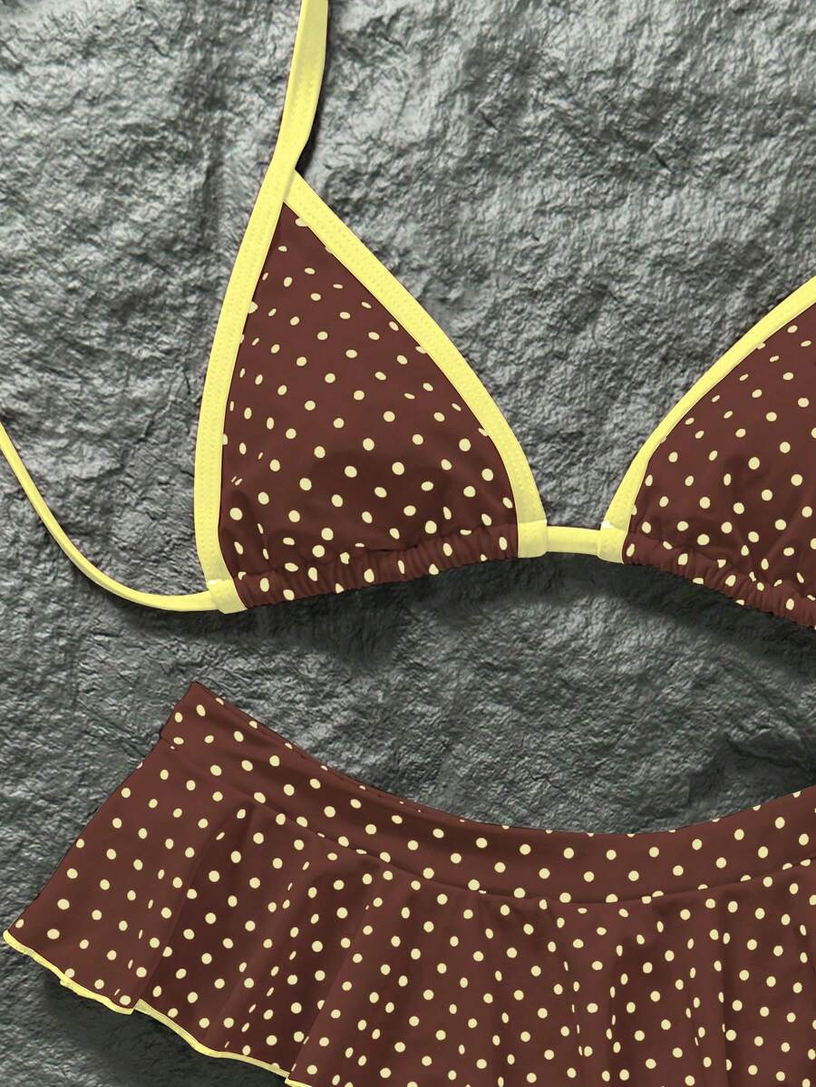 Women's 70s retro black and white polka dot bikini set featuring a halter triangle top and ultra low waist bottoms.