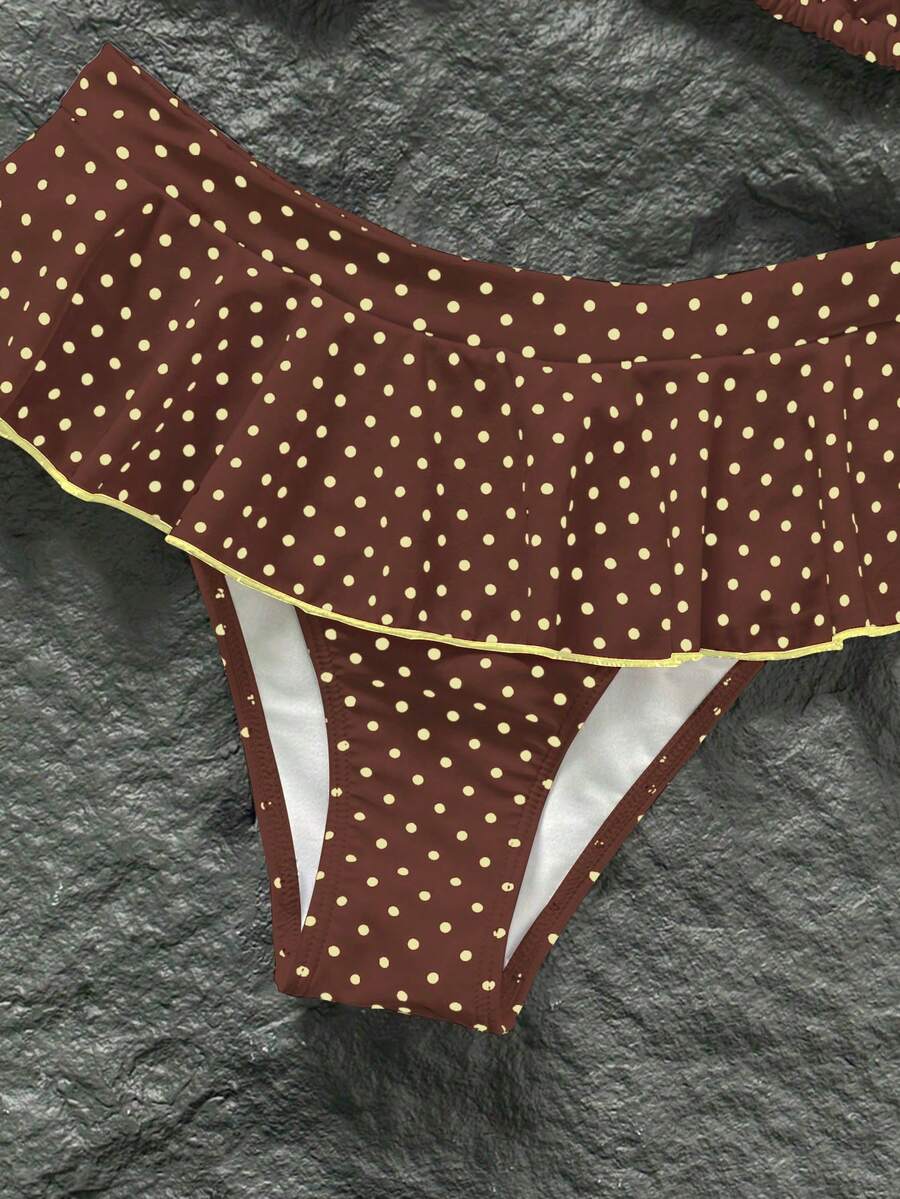 Women's 70s retro black and white polka dot bikini set featuring a halter triangle top and ultra low waist bottoms.