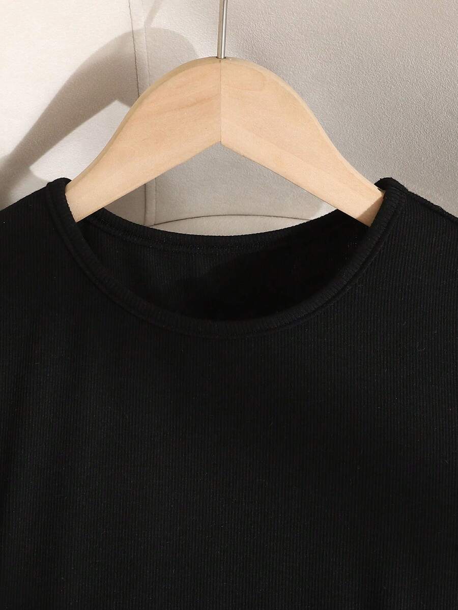 Tween girl wearing an apricot short sleeve A-line dress featuring a round neck, high waist with a belt, and flared hem.